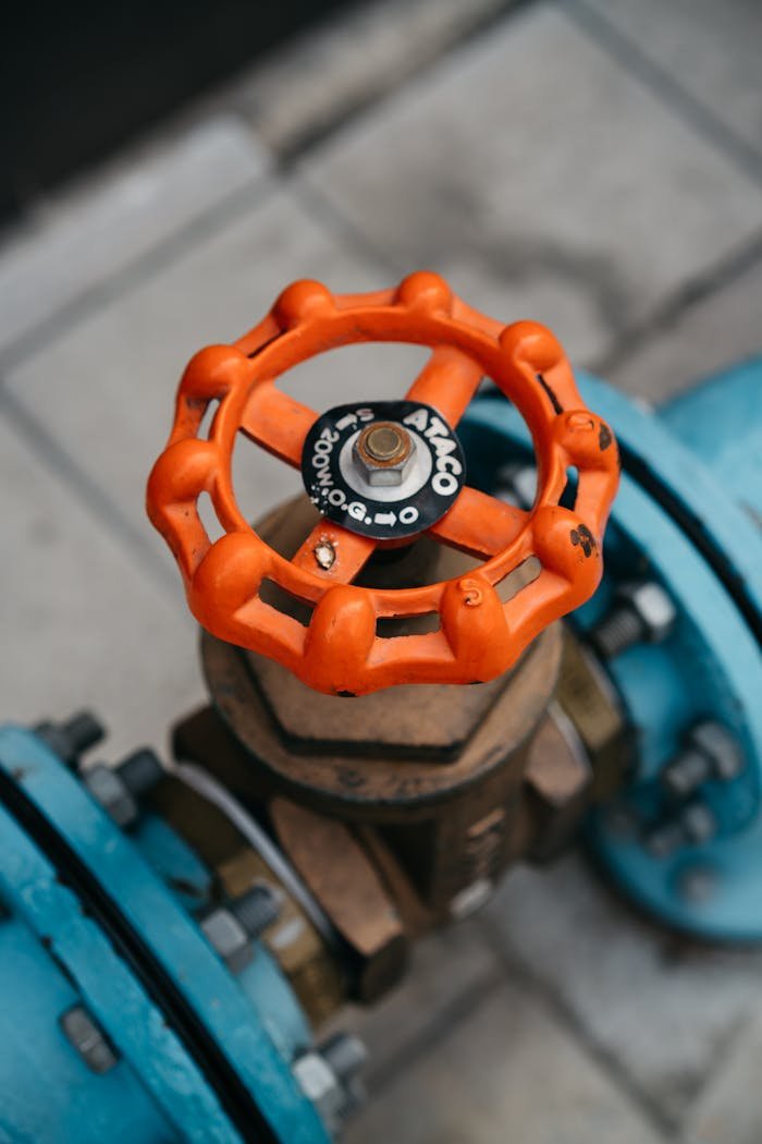 why-choose-us Close-up of orange valve on a blue pipeline, showcasing industrial equipment details.